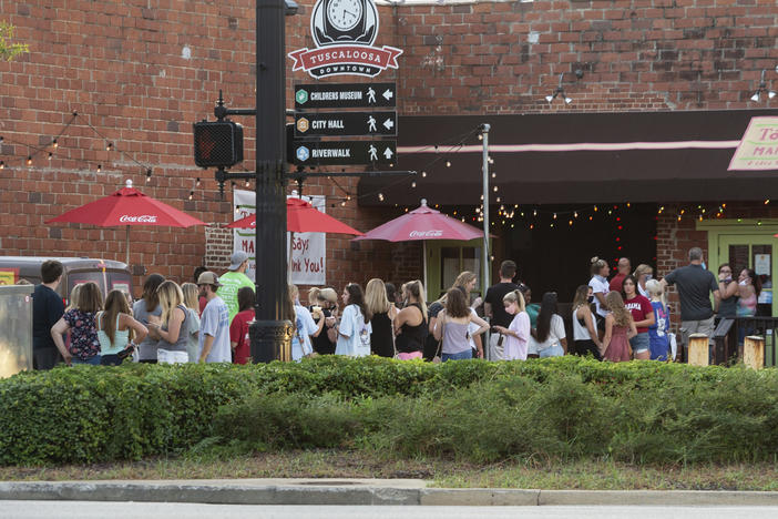 People line up outside to order food from a taco restaurant in Tuscaloosa, Ala. Social media images of crowds outside bars drew scrutiny last weekend in the city, which is home to the University of Alabama.