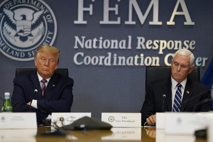President Donald Trump and Vice President Mike Pence listen during a Hurricane Laura briefing at FEMA headquarters in Washington.