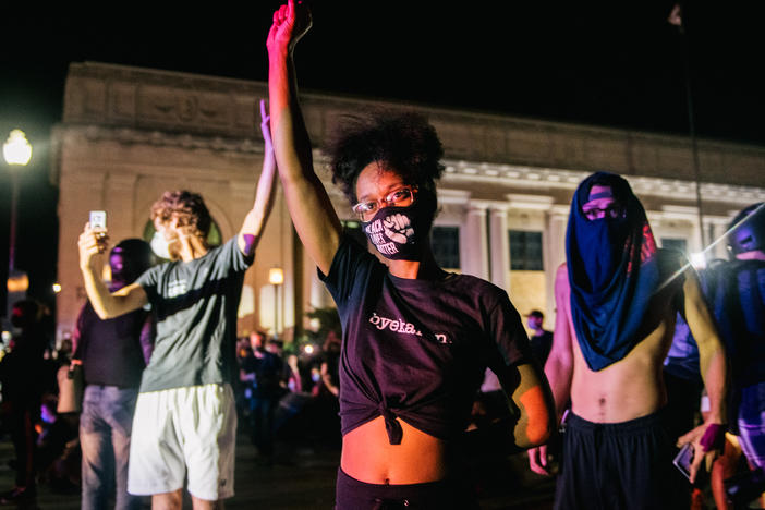 Protesters raise their fist in the air in front of law enforcement last month in Kenosha, Wis., after the police shooting of Jacob Blake.