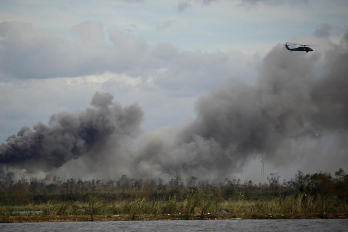 A helicopter flies over a chemical fire at BioLab plant after Hurricane Laura made landfall in Westlake, La., on Aug. 27, 2020.