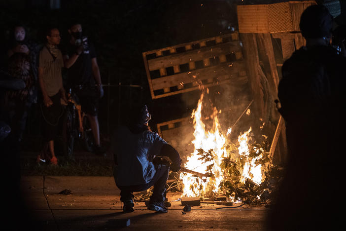 A protester in Kenosha lights some debris on fire on Aug. 26, 2020.