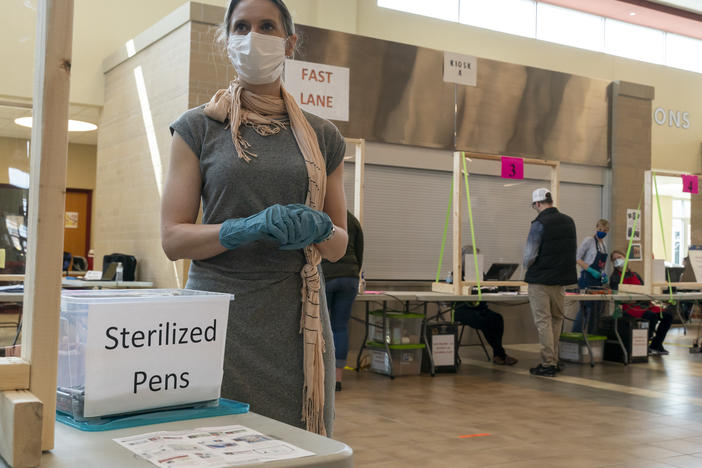 A poll worker in Sun Prairie, Wis., is seen during the state's April 7 primary. A record number of Wisconsin voters are expected to vote by mail this fall, but polls indicate Republicans are far more likely to vote in person, which has some GOP officials worried it could hurt the party's chances.