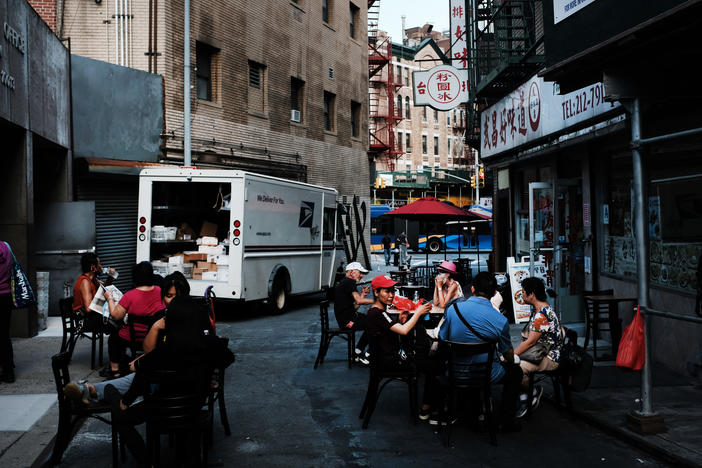 People eat in an outdoor dining area in New York City's Chinatown on Aug. 10. Economists warn spending may suffer this month.