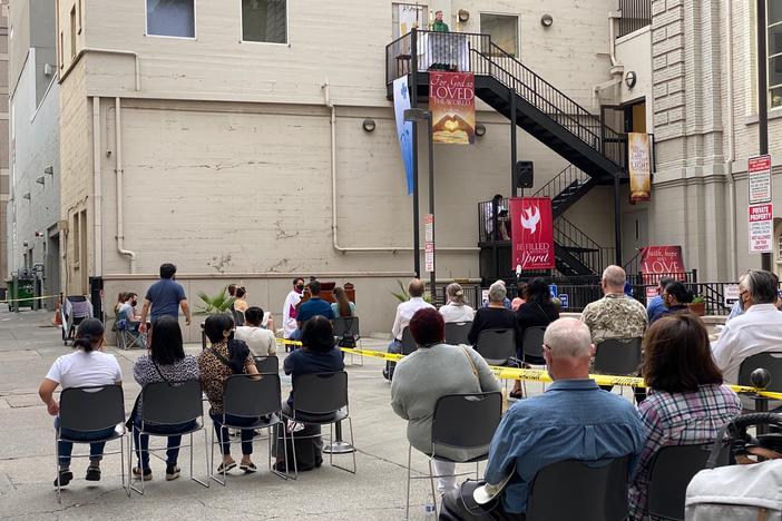 Father Michael O'Reilly preaches from a third-floor fire escape in a Sacramento alley while indoor worship services are prohibited due to COVID-19 heath restrictions.