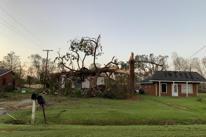 A home near Iowa, La., was crushed by a snapped tree after Hurricane Laura made landfall with 150 mph winds Thursday. The area is facing two disasters at once.