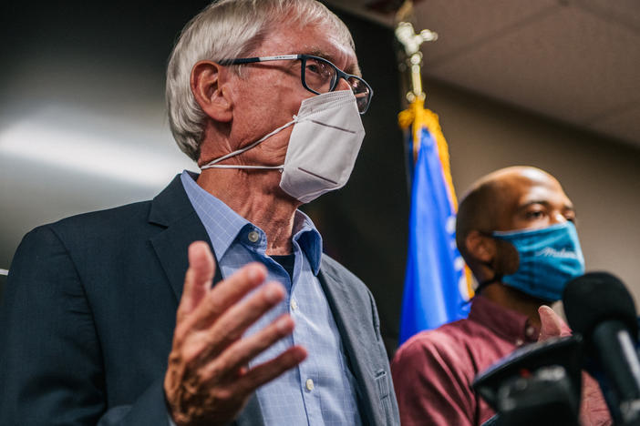 Wisconsin Gov. Tony Evers (left) speaks at a news conference held Thursday in Kenosha, Wis., to discuss recent civil unrest surrounding the police shooting of Jacob Blake, a Black man who was shot several times in the back in front of his children.