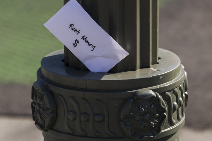 A paper envelope written with the words "Rent Money $" is left tucked in a lighting pole in April in the Boyle Heights area of Los Angeles. Amid massive job losses due to COVID-19, California Gov. Gavin Newsom signed an extended eviction moratorium on Monday.