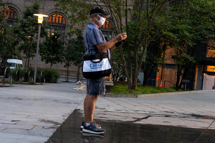 A Census Bureau worker with a face covering stands in a park in New York City in August. The bureau confirmed on Tuesday that door knocking is ending in some areas earlier than Sept. 30.