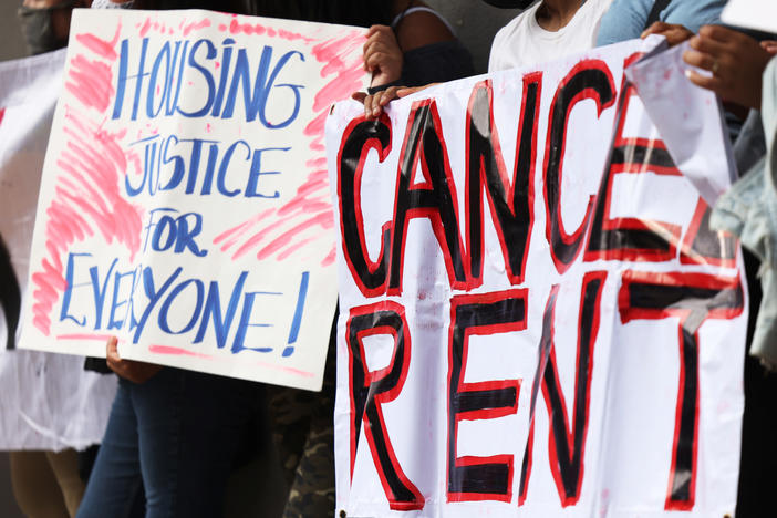 Demonstrators hold up signs as they gather at Brooklyn Housing court during a 'No Evictions, No Police' national day of action in New York City.