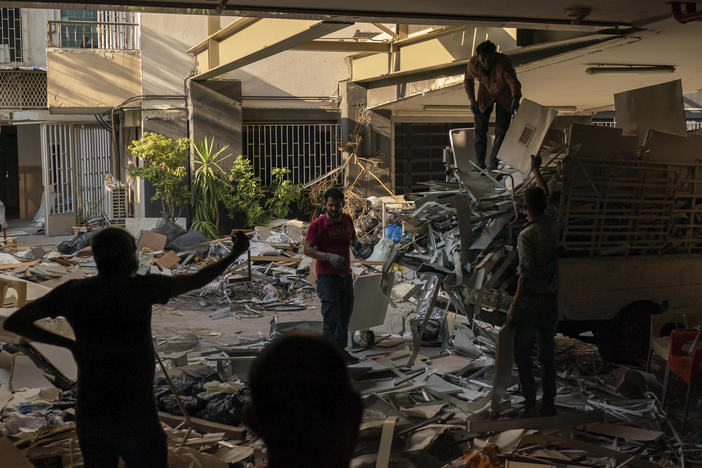 Workers remove debris from a hospital that was heavily damaged in last month's explosion in Beirut. Lebanon's interim health minister, Hamad Hasan, told local media last month that the health system was "on the brink" of being overwhelmed because of the needs of blast victims and COVID-19 patients.