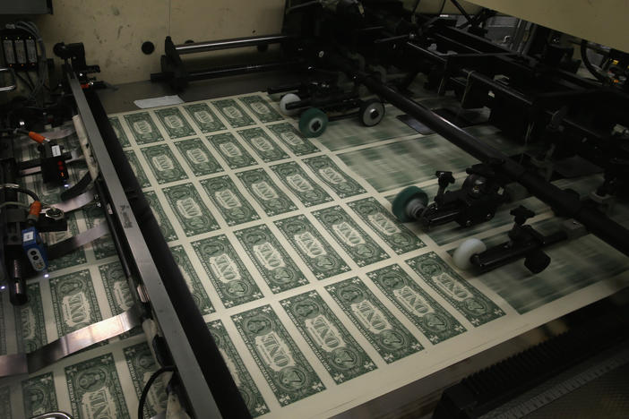 Sheets of $1 bills run through the printing press in 2015 at the U.S. Bureau of Engraving and Printing in Washington, D.C. National debt is expected to reach an all-time high of 107% of gross domestic product in 2023.