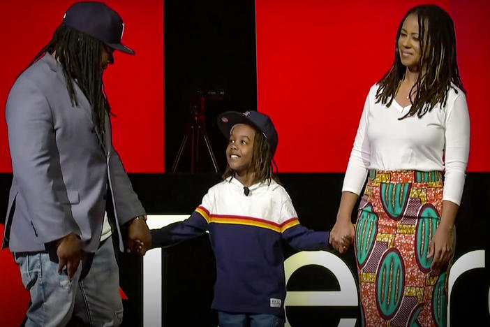 Shaka Senghor (left), Ebony Roberts (right), and their son Sekou speak on the TED stage.