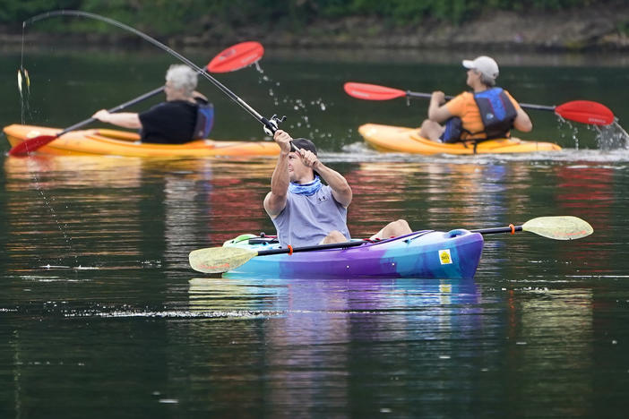 A fisherman in a kayak makes a cast on Lake Arthur at Moraine State Park in Portersville, Pa. Sales of camping, outdoor and recreational equipment have been surging.