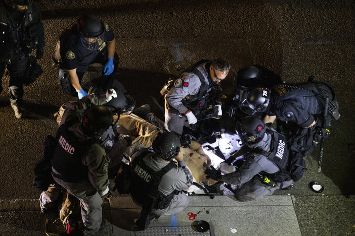 Emergency personnel treat Aaron Danielson in Portland, Ore., Aug. 29. The man suspected of killing Danielson, Michael Reinoehl, was killed by law enforcement agents as they attempted to arrest him Thursday night.