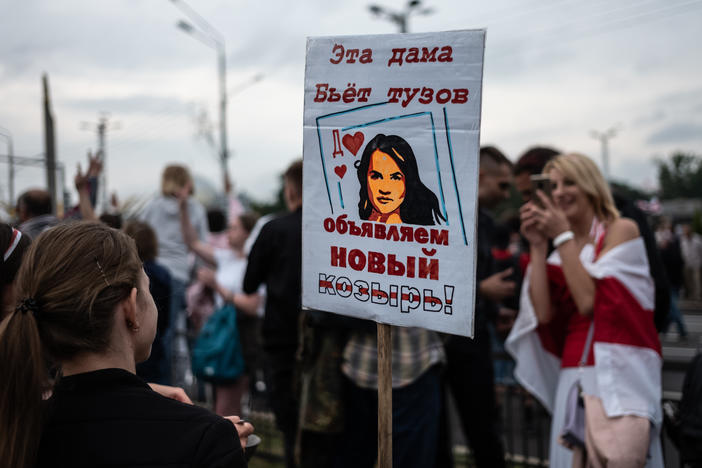 Anti-government protesters hold a sign with a picture depicting Belarusian opposition leader Svetlana Tikhanovskaya as a card that trumps an ace on Aug. 23 in Minsk.