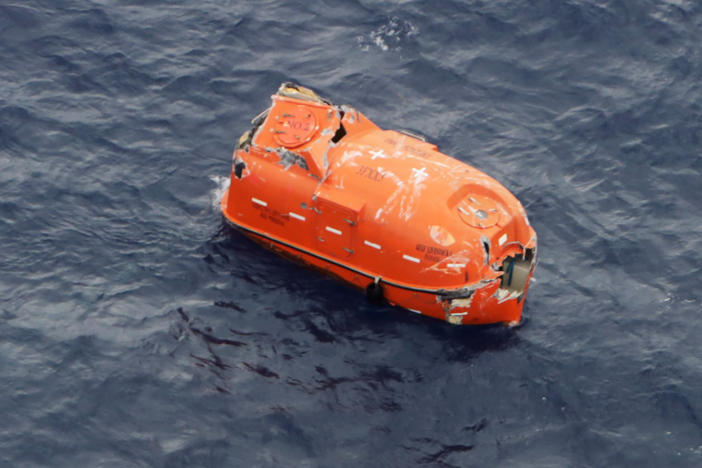 An unoccupied lifeboat drifts near Kodakarajima island. Japanese authorities are racing to find dozens of missing sailors from a cargo ship that sank in a typhoon.