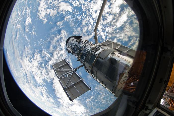 An STS-125 crew member onboard the space shuttle Atlantis snaps a still photo of the Hubble Space Telescope following grapple of the giant observatory by the shuttle.