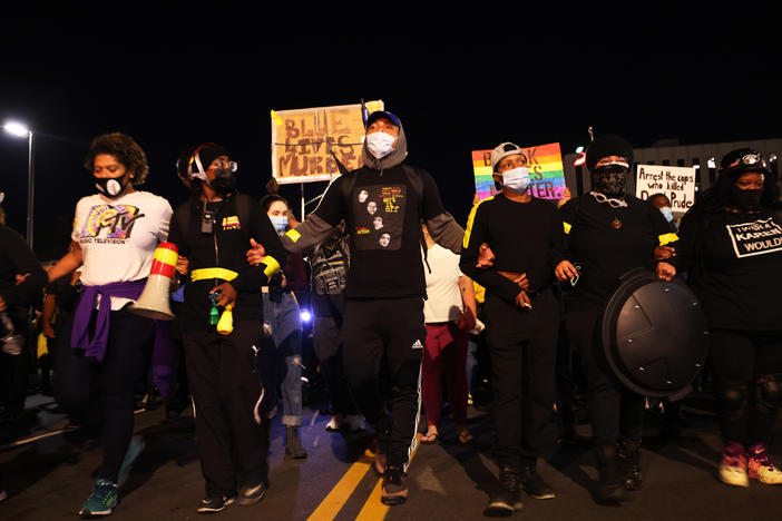 Demonstrators lock arms as they march for Daniel Prude on Friday in Rochester, N.Y. Prude died after being arrested on March 23 by Rochester police officers, who had placed a "spit hood" over his head and pinned him to the ground while restraining him.