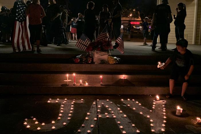 A boy lights a candle commemorating Aaron 'Jay' Danielson on Saturday night. Danielson, 39, was a member of Patriot Prayer. He was killed during a Portland protest on Aug. 29.