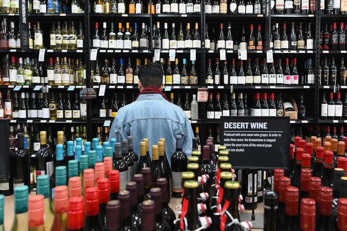 A patron stands in front of a shelf full of wine bottles at a liquor story in the Brooklyn borough of New York City on March 20.