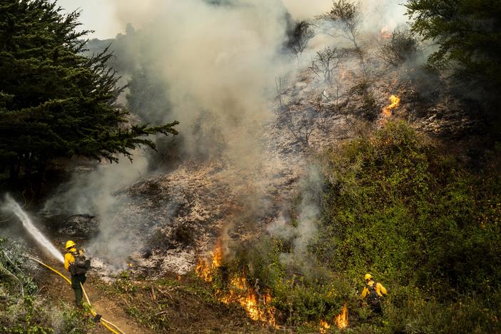 The Dolan Fire, pictured Aug. 22, has burned more than 37,000 acres along the central California coast. On Tuesday, more than a dozen firefighters battling the blaze deployed portable fire shelters, and three were hospitalized with injuries.