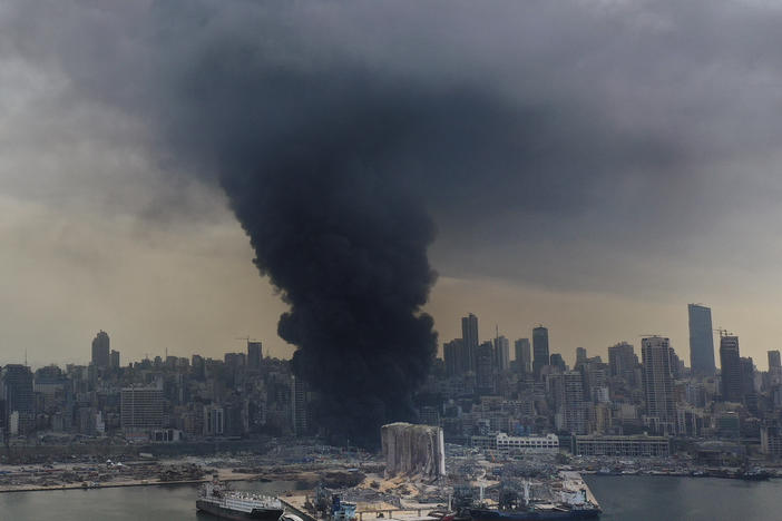 A column of black smoke rises from a fire Thursday at a warehouse at Beirut's port. A Lebanese official said the fire is under control, according to local media.