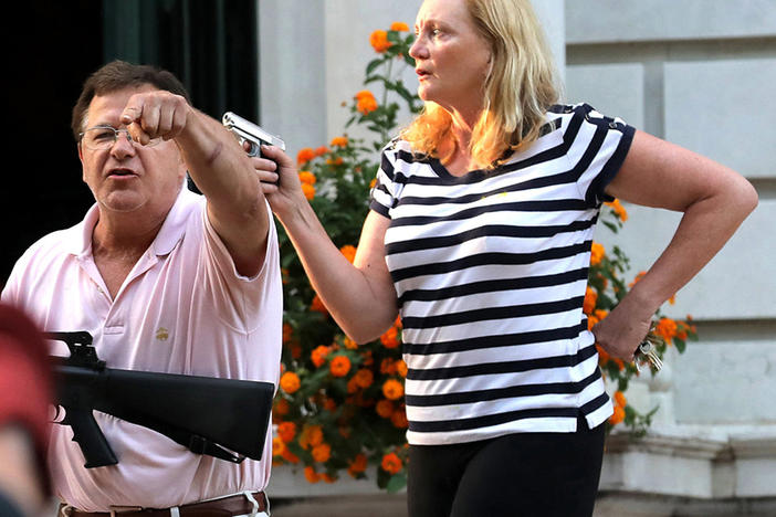 Armed homeowners Mark and Patricia McCloskey confront protesters marching to St. Louis Mayor Lyda Krewson's house on June 28. The St. Louis Metropolitan Police has issued citations for trespassing to nine protesters, and these are under review by the city counselor's office.