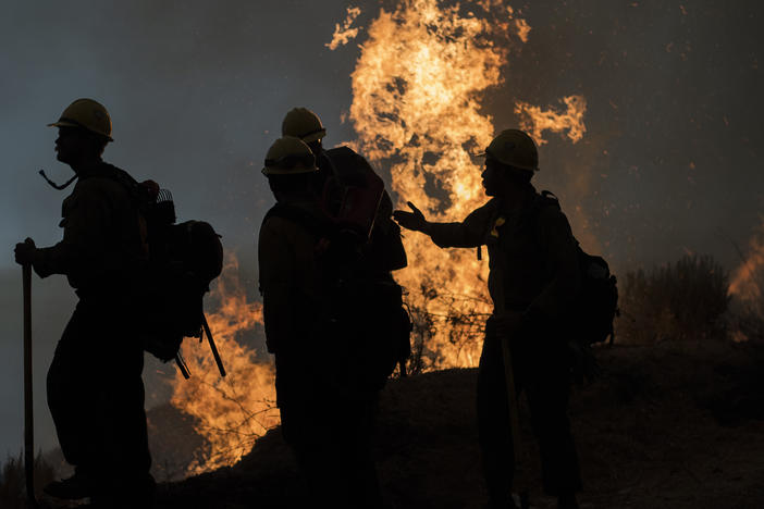 Firefighters monitor a controlled burn along Nacimiento-Fergusson Road to help contain the Dolan Fire near Big Sur, Calif., on Friday.