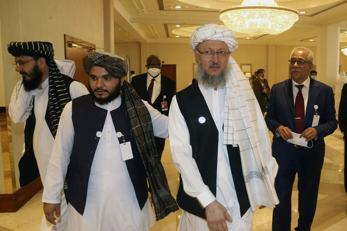 Abdul Salam Hanafi (right), a member of the Taliban negotiating team, heads to the opening session of peace talks between the Afghan government and the Taliban in Doha, Qatar, on Saturday.