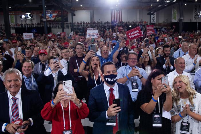People cheer as President Trump arrives for an indoor campaign rally Sunday night at Xtreme Manufacturing in Henderson, Nev.