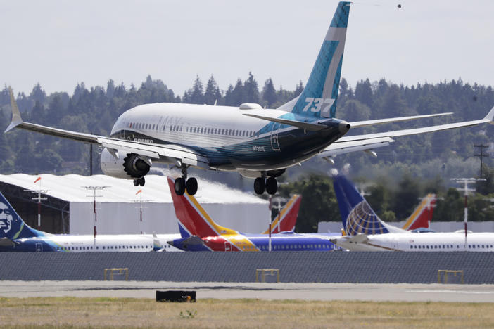 A Boeing 737 Max heads to a landing past grounded Max jets at Seattle's Boeing Field after a test flight in June. It was the first of three days of recertification test flights that mark a step toward returning the aircraft to passenger service.