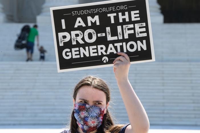 An anti-abortion-rights activist demonstrates in front of the U.S. Supreme Court in June. Many Trump voters (or potential Trump voters) bring up abortion in explaining their voting rationale.