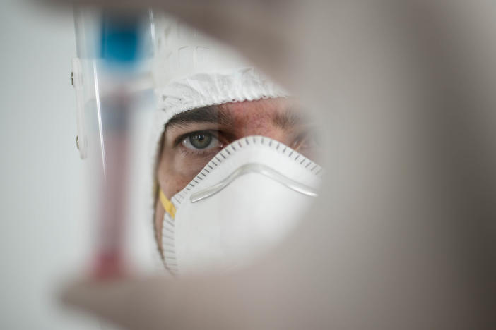 A researcher holds a tube containing the coronavirus.