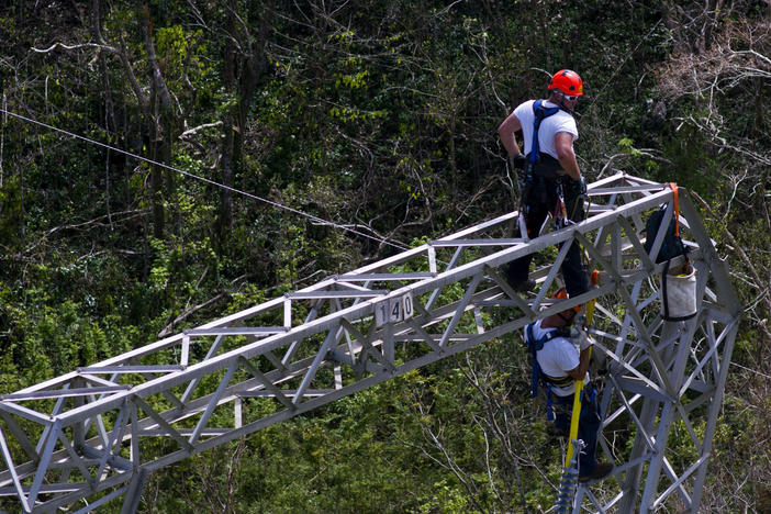 Workers restore power lines damaged by Hurricane Maria in Barceloneta, Puerto Rico, in 2017. The Trump administration says it will award nearly $13 billion in infrastructure grants to help the island recover from the storm that hit three years ago.