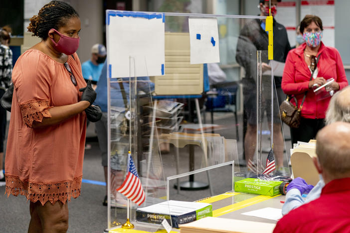 A voter stands by for her ballot as people wait more than four hours for early voting Friday in Fairfax, Va.