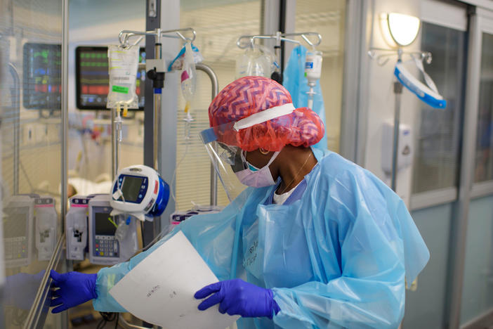 Niticia Mpanga, a registered respiratory therapist, checks on an ICU patient at Oakbend Medical Center in Richmond, Texas. The mortality rates from COVID-19 in ICUs have been decreasing worldwide, doctors say, at least partly because of recent advances in treatment.