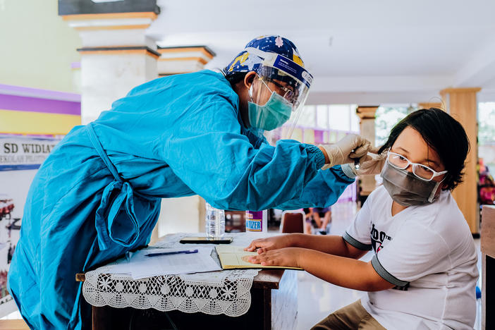 Vaccines for measles-rubella and cervical cancer are administered at a school in Jimbaran, Indonesia. Vaccination rates have dropped during the pandemic.