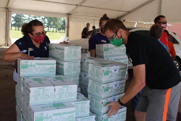 Each week, police in Lexington, Neb., cordon off several blocks near the edge of town, where roughly 700 cars will line up for USDA Farmers to Families food boxes. Above, volunteers organize boxes on Aug. 27, 2020.