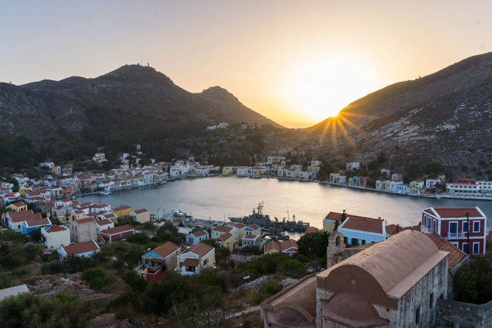 The Greek island of Kastellorizo, shown here at sunset from the top of an ancient castle, is a little over a mile away from the Turkish shore. Known for its architecture, turquoise sea and friendship with the neighbor Turks, it's recently become a pawn in a geopolitical dispute between the Greek and Turkish governments over hydrocarbons and maritime borders.