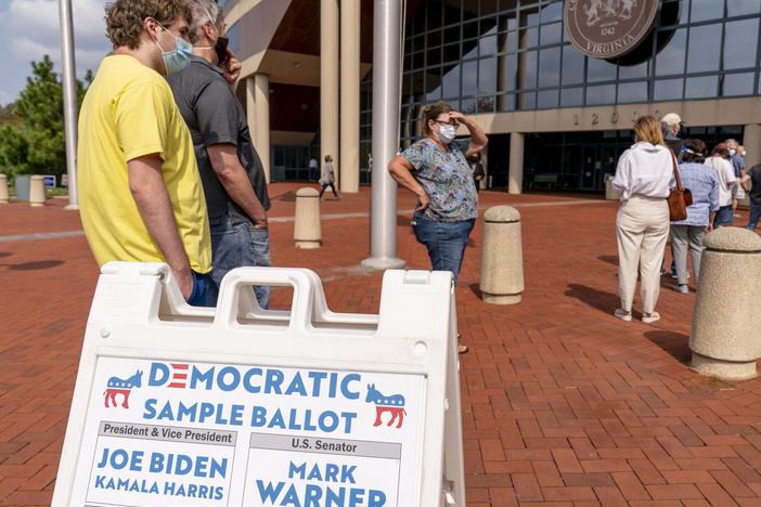 A Democratic sample ballot is on display as hundreds wait in line for early voting at Fairfax County Government Center on Friday in Fairfax, Va.