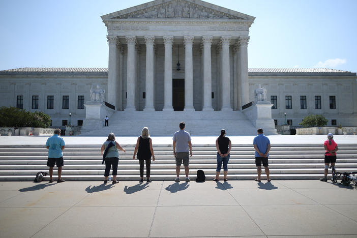 Demonstrators pray in front of the U.S. Supreme Court on July 8, a day the court ruled that employers with religious objections can decline to provide contraception coverage under the Affordable Care Act. With the death of Ruth Bader Ginsburg, the ACA's future is in doubt.