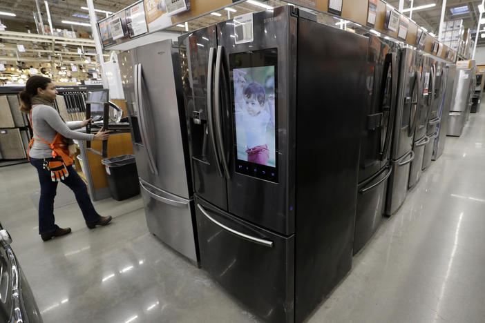 A worker pushes a cart past refrigerators at a Home Depot in Boston in January, before the coronavirus pandemic threw a monkey wrench into the supply and demand of major appliances.