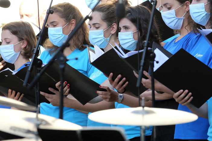 The Centers for Disease Control and Prevention briefly posted new guidance to its website stating that the coronavirus can commonly be transmitted through aerosol particles, which can be produced by activities like singing. Here, choristers wear face masks during a music festival in southwestern France in July.