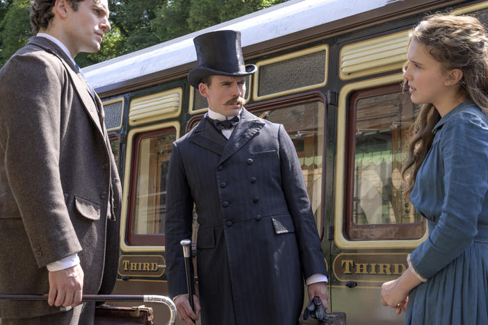 "The train's afoot!": (L to R) Sherlock (Henry Cavill) and Mycroft (Sam Claflin) literally look down on their younger sister Enola (Millie Bobby Brown) in Netflix's <em>Enola Holmes.</em>