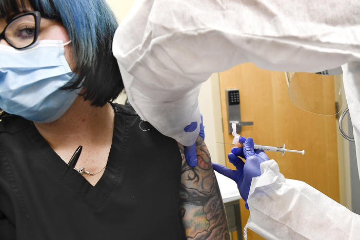 Nurse Kathe Olmstead (right) gives volunteer Melissa Harting an injection in a study of a possible COVID-19 vaccine developed by the National Institutes of Health and Moderna Inc.
