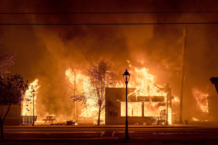 Buildings are engulfed in flames as a wildfire ravages Talent, Ore., on Sept. 8, 2020. Unfounded rumors that left-wing activists were behind the fires went viral on social media, thanks to amplification by conspiracy theorists and the platforms' own design.