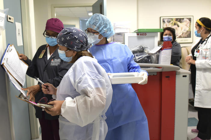 Researchers in Miami hold syringes containing either a placebo or the candidate COVID-19 vaccine from Moderna. Their work is part of a phase three clinical trial sponsored by the National Institutes of Health.