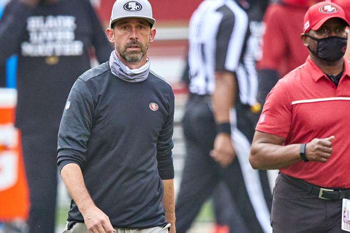 The NFL has fined San Francisco 49ers head coach Kyle Shanahan and two other coaches for not following rules about keeping their faces covered. Here, Shanahan walks off the field after his team's Sept. 13 game against the Arizona Cardinals.
