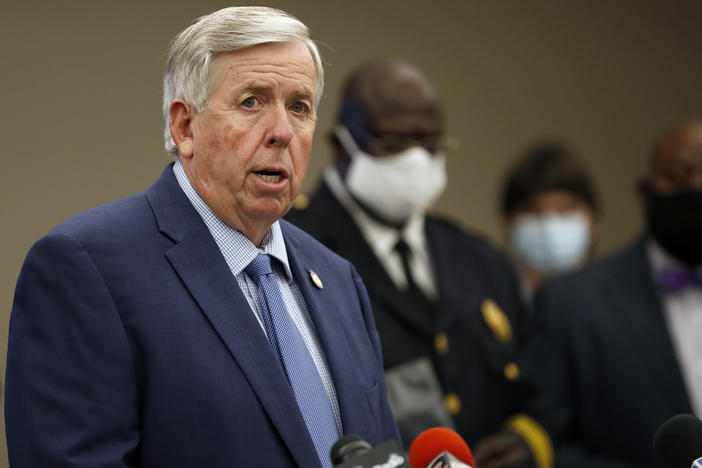 Missouri Gov. Mike Parson, here at an August news conference in St. Louis, says he and his wife, Teresa Parson, "are both fine" after testing positive for the coronavirus.