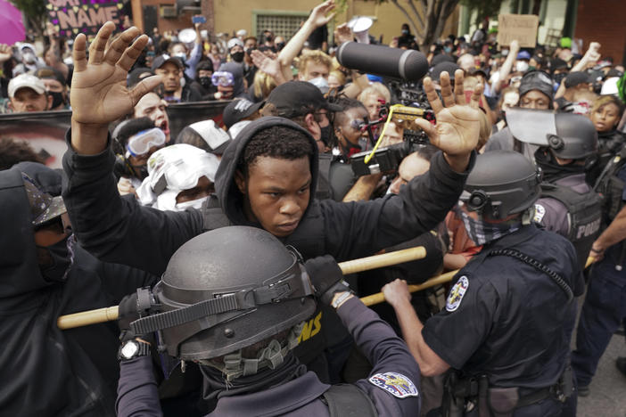 Police and protesters converge during a demonstration, Wednesday in Louisville, Ky. A grand jury has indicted one officer on criminal charges six months after Breonna Taylor was fatally shot by police in Kentucky.